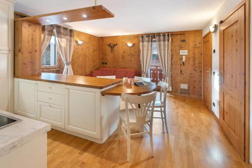 a kitchen with a table and a dining room at Appartamento Le Cigamole in Valfurva
