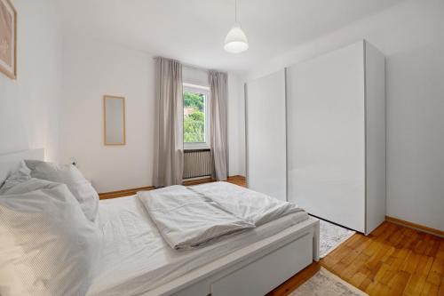 a bedroom with a white bed and a mirror at Ferienwohnung Merzig in Merzig