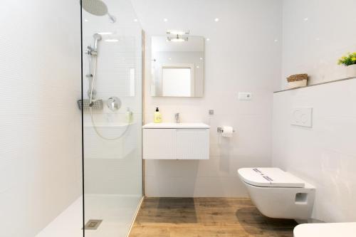 a white bathroom with a toilet and a sink at Luxury Sea view Apartment in Nerja