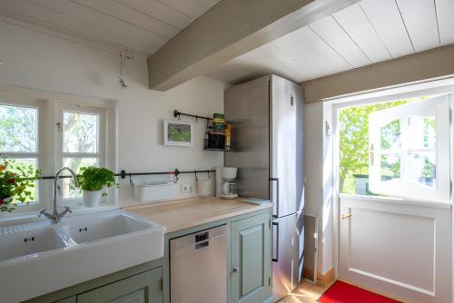 a kitchen with a sink and a refrigerator at Ferienwohnungen Appelhus in Pellworm