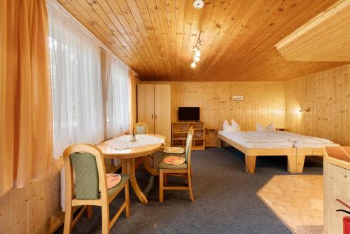a room with a table and a bed and a table and chairs at Bungalow 26 - Kimbucht in Reichendorf