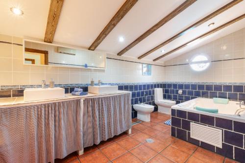 a bathroom with two sinks and a toilet at Casa rural cavila in Pliego