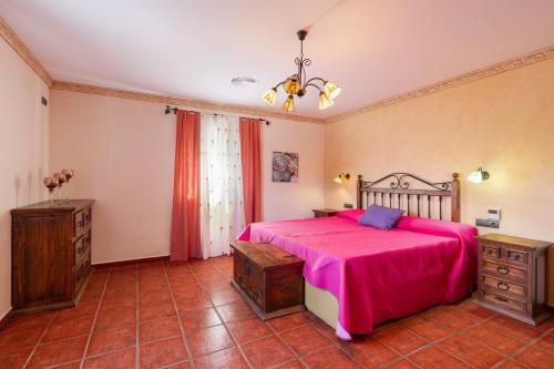 a bedroom with a large bed with a pink blanket at Casa rural cavila in Pliego