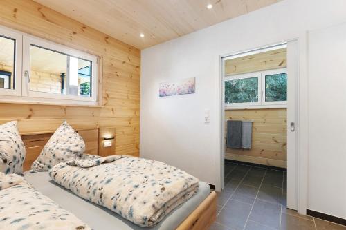 a bedroom with a bed and two windows at Mettmapark - Chalet 2 in Grafenhausen