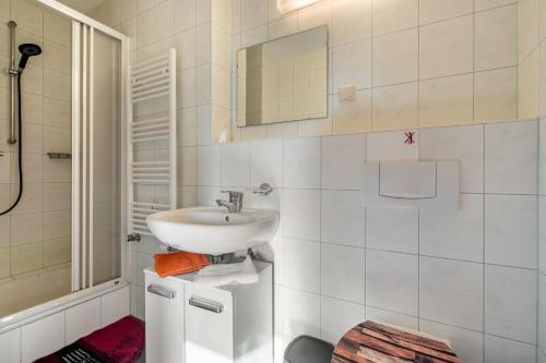 a white bathroom with a sink and a shower at Ferienhaus Tanneberg in Tanneberg