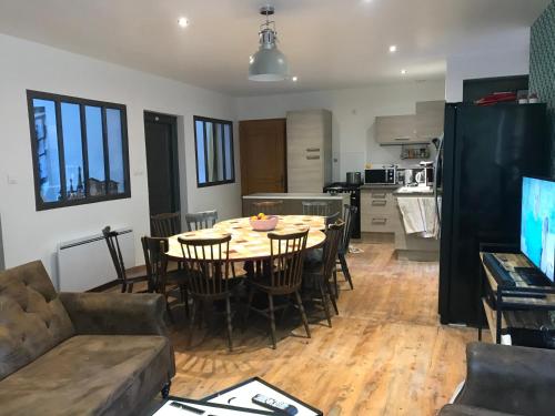 a kitchen and living room with a table and chairs at Vacance 16 Pers in La Bourboule