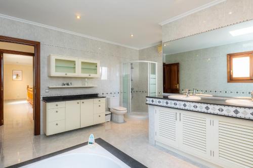 a large bathroom with two sinks and a toilet at Cas Bunyoler in Cala Ratjada