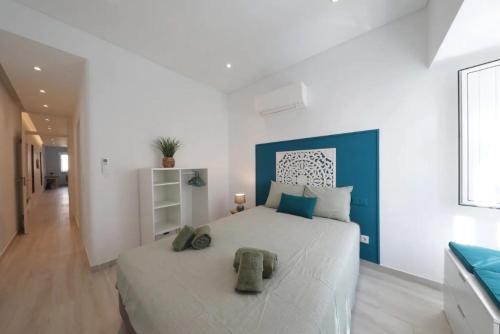 a bedroom with a large white bed with blue accents at Bougainvillea House in Tavira
