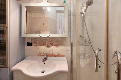 a bathroom with a sink and a shower with a mirror at A due passi dal mare in Pietra Ligure