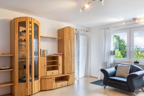 a living room with a book shelf and a chair at Ferienwohnung Sigrun in Niedenstein