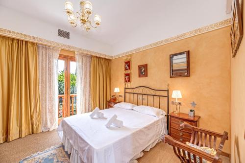a bedroom with a large white bed and a window at Villa Tramontana in Lloseta