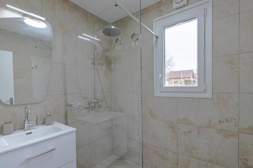 a bathroom with a shower and a sink and a mirror at Gite du cerisier in Lanouaille