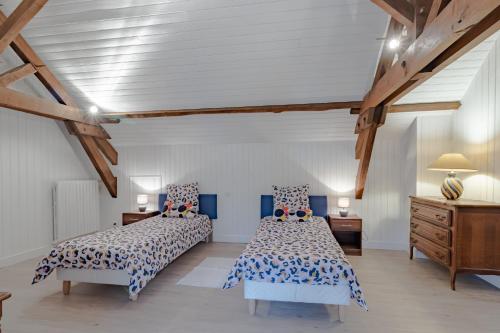 a bedroom with two beds and a dresser at Gite du cerisier in Lanouaille