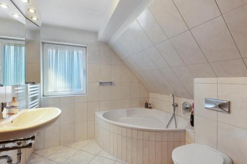 a white bathroom with a tub and a sink at Ferienwohnung am Hügel in Schmallenberg
