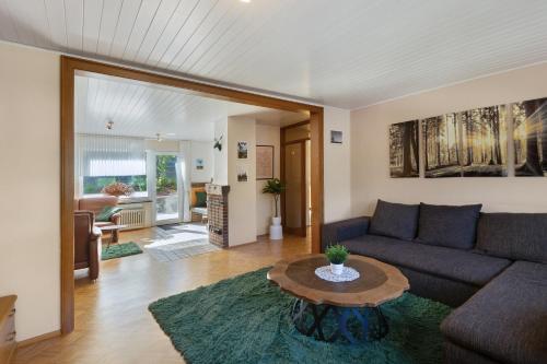 a living room with a couch and a table at Ferienwohnung am Hügel in Schmallenberg