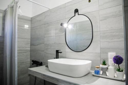 a bathroom with a white sink and a mirror at Sunset Sea View Cottage in Nea Potidaea