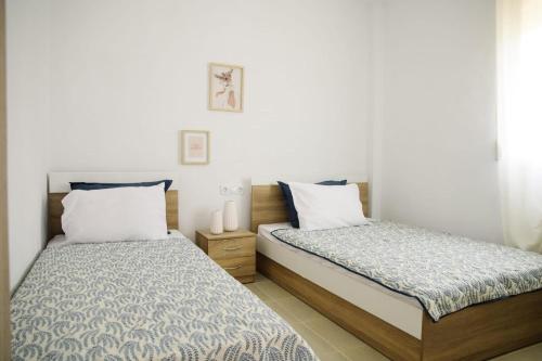 two beds sitting next to each other in a bedroom at Sunset Sea View Cottage in Nea Potidaea