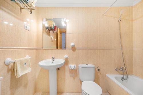 a bathroom with a toilet and a sink and a tub at Viñamar 7 in La Mata