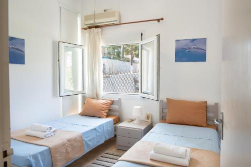 a bedroom with two beds and a window at Stunning Views Kantouni Beach in Kalymnos