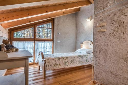 a bedroom with a bed and a window at Baita Al Rossat in Sant’Orsola