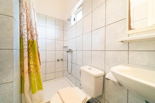 a white bathroom with a toilet and a sink at Arianna Studio 12 in Paleokastritsa