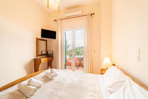 a bedroom with a bed and a door to a patio at Arianna Studio 12 in Paleokastritsa