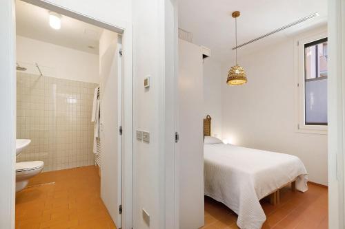 a white bedroom with a bed and a toilet at U Canetta 2 in Pietra Ligure