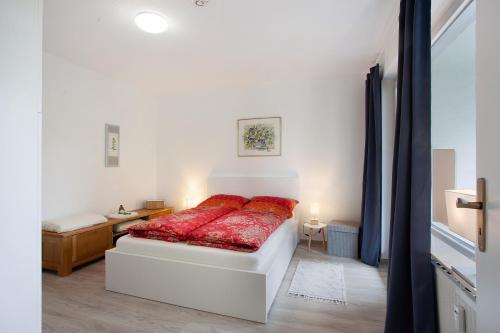 a bedroom with a bed with a red blanket at Ferienwohnung Rübezahl in Brilon