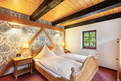 a bed in a room with a wooden ceiling at Weingut Schuh in Coswig