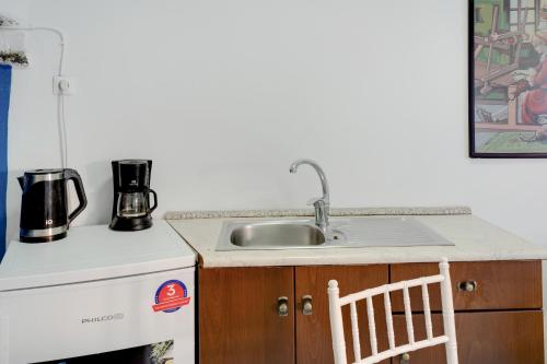 a kitchen counter with a sink and a stove at Politimis Studio N7 in Amorgos