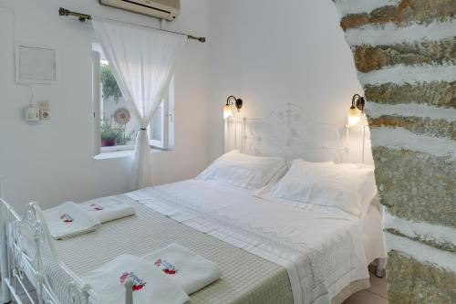 a white bed with white towels and a window at Politimis Studio N7 in Amorgos