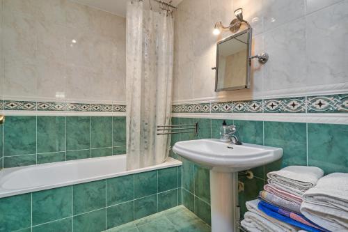 a bathroom with a sink and a tub and a mirror at Beachfront apartment Torrox Costa in Torrox