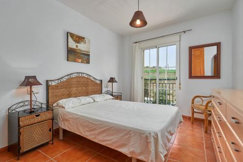 a bedroom with a bed and a large window at Beachfront apartment Torrox Costa in Torrox