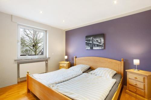 a bedroom with a bed with a purple wall at Ferienwohnung Keil in Balve