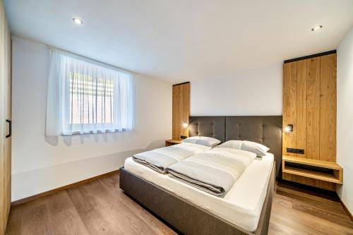 a bedroom with a bed and a window at Sunnseitn Lodge Apartment Alps in Moso