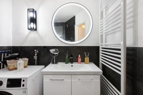 a bathroom with a white sink and a mirror at Domus Lux 404 in Bad Säckingen