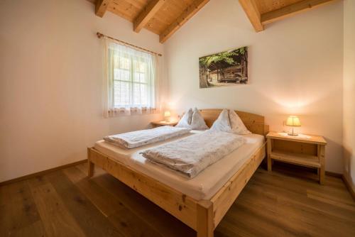 a bedroom with a wooden bed with two night stands at Kreuzhof links in Novacella