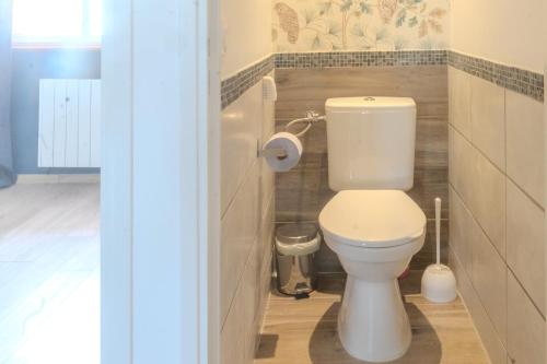 a bathroom with a white toilet in a room at Le Luna in Vindelle
