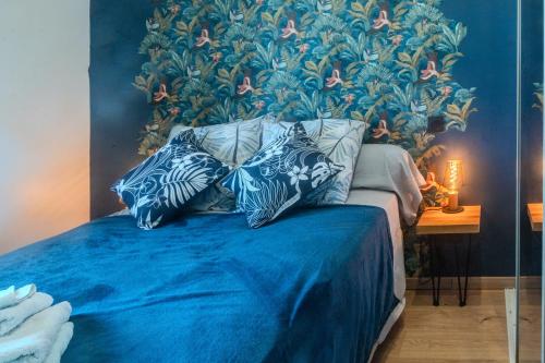 a bedroom with a blue bed with two pillows at Le Luna in Vindelle