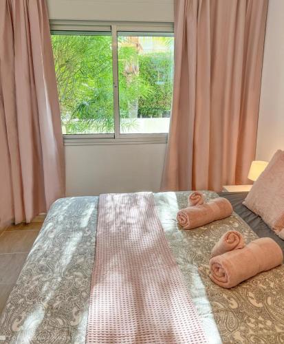 a bedroom with two towels on a bed with a window at Apartamento Isla Feliz in San Miguel de Abona