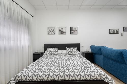 a bedroom with a bed and a blue couch at Casa Matyas in Icod de los Vinos