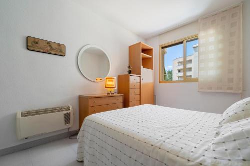 a bedroom with a white bed and a mirror at Cambrils park in Cambrils