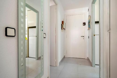 a hallway with a mirror and a white door at Cambrils park in Cambrils