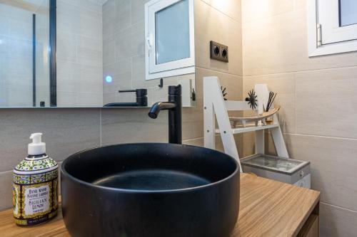 a bathroom with a black bowl sink on a counter at Ca La Nyca in Tossa de Mar