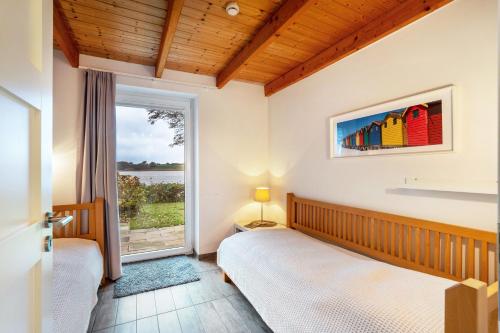 a bedroom with two beds and a large window at Weidenuferhaus in Kosel
