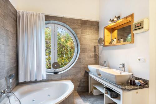 a bathroom with two sinks and a large window at Weidenuferhaus in Kosel