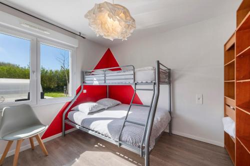 a bedroom with a bunk bed and a chair at Maison d'Elise in Kerlouan