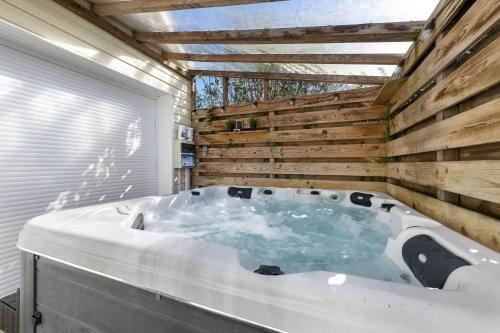 a hot tub in a bathroom with a wooden wall at Maison d'Elise in Kerlouan