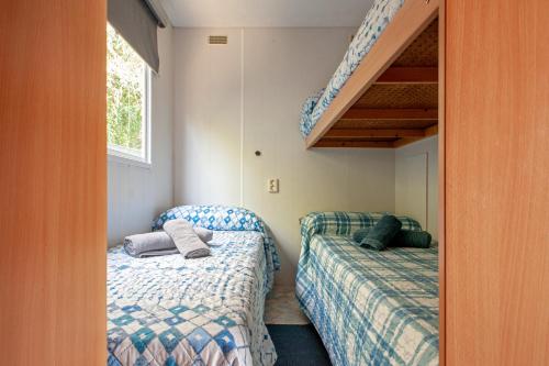 two beds in a small room with a staircase at Oasis on the river 2 in Marina di Pisa