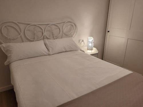 a bedroom with a white bed with a headboard at Apartamento Ejido Centro in El Ejido